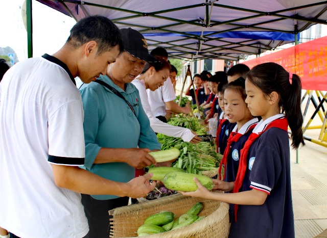 來往的群眾在孩子們熱情的介紹下購買蔬菜。 (2).jpg