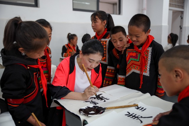 寧職院思源義工師生團隊成員在指導美姑縣學生學書法 錢成峰 攝.jpg 寧職院思源義工師生團隊成員在指導美姑縣學生學書法 錢成峰 攝.jpg