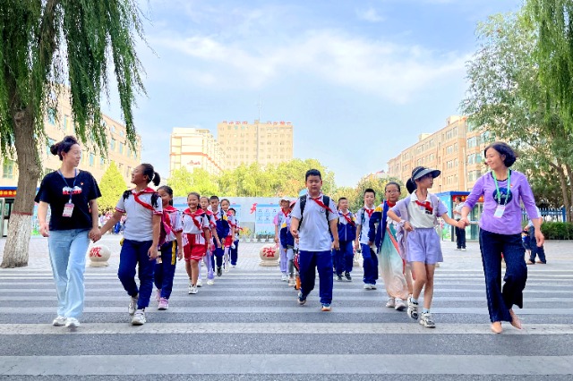 01 臨澤縣城關(guān)小學(xué)“紅燭先鋒”護(hù)學(xué)崗教師護(hù)送學(xué)生放學(xué)。謝靜 攝.jpg