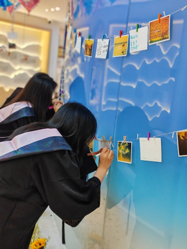 浙江萬里學(xué)院畢業(yè)生在“青春寄語墻”留言 學(xué)校供圖.jpg