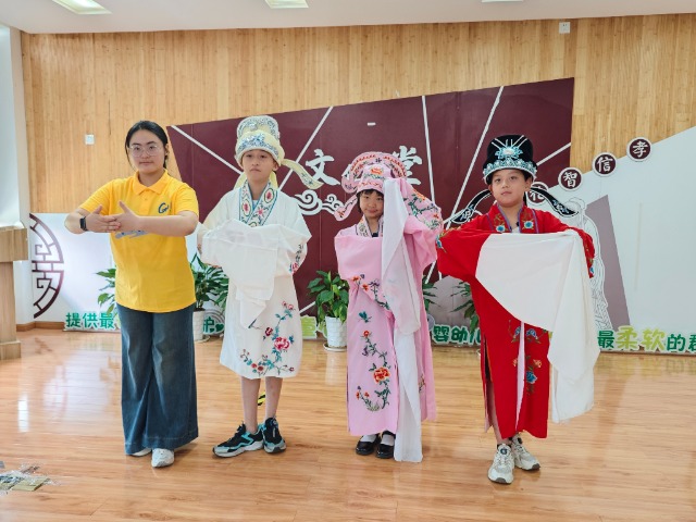 寧波職業(yè)技術(shù)大學(xué)“拾夢(mèng)非遺”服務(wù)隊(duì)教小朋友們學(xué)唱傳統(tǒng)戲曲 學(xué)校供圖.jpg