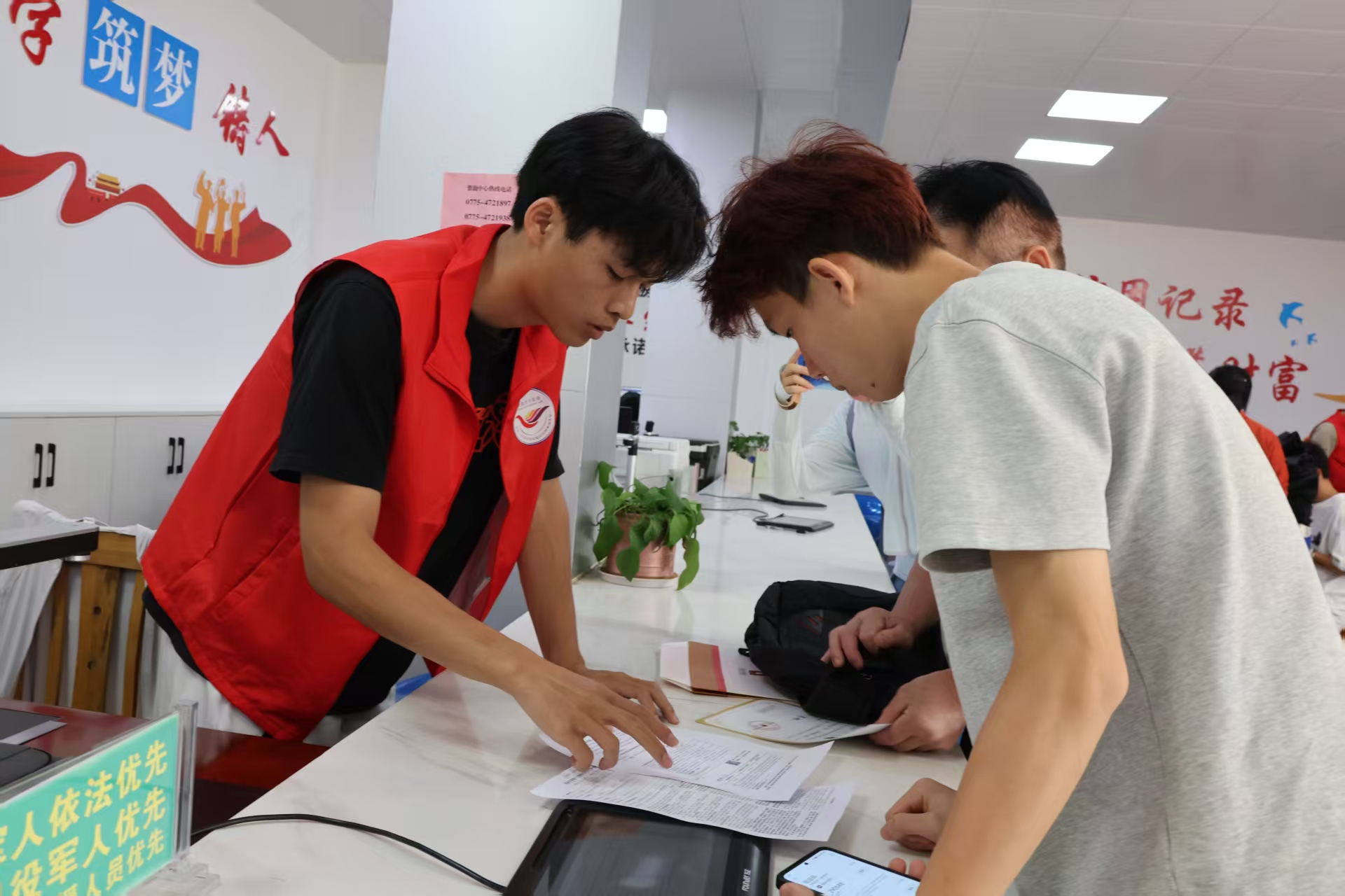 覃塘區(qū)：志愿者指引前來(lái)辦理貸款業(yè)務(wù)的學(xué)生.jpg