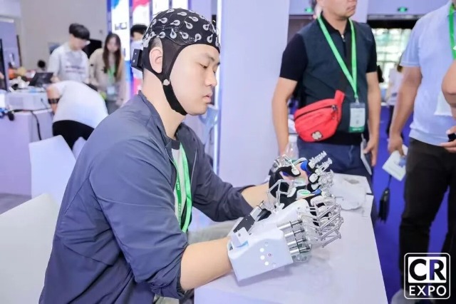 團(tuán)隊(duì)成員在2025中國(guó)國(guó)際福祉博覽會(huì)暨中國(guó)國(guó)際康復(fù)展覽會(huì)展示手部康復(fù)機(jī)器人 學(xué)校供圖.jpg