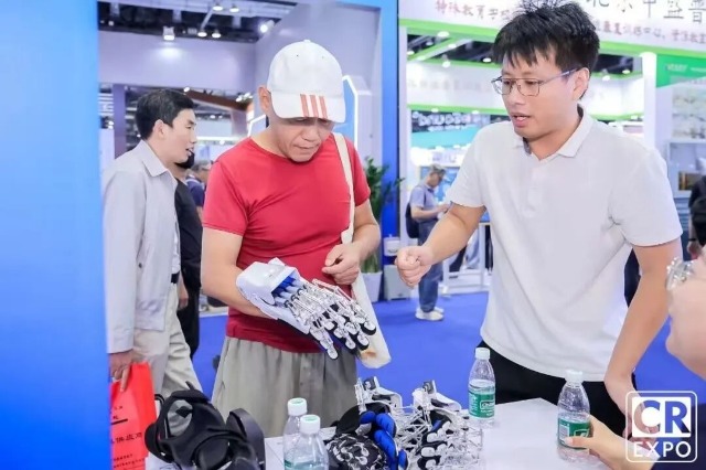 于金須在博覽會(huì)上向來賓介紹手部康復(fù)機(jī)器人 學(xué)校供圖.jpg